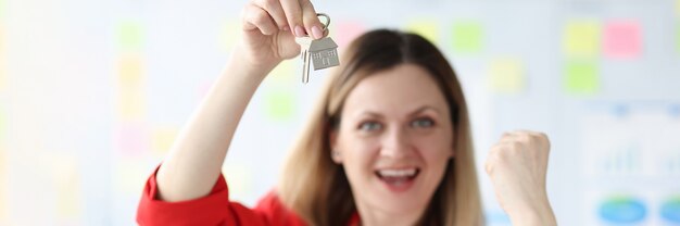 Happy smiling woman holding the keys to apartment buying your own home concept