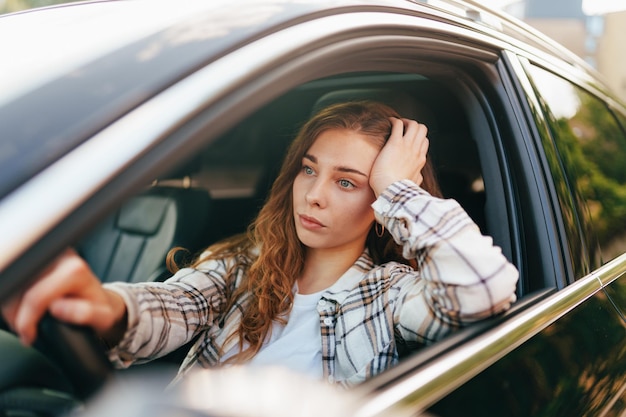 happy smiling woman inside a car driving in the street