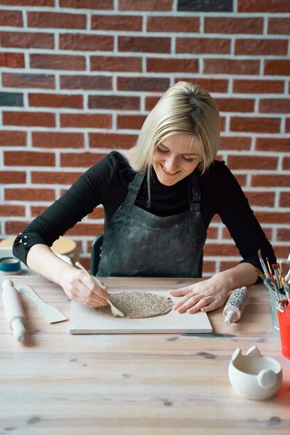 Happy smiling woman making ceramic plate. Concept for woman in freelance