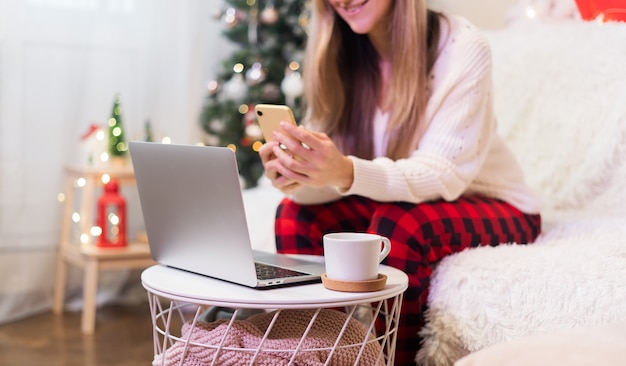 Happy smiling woman in red Santa hat having a video call or taking selfie