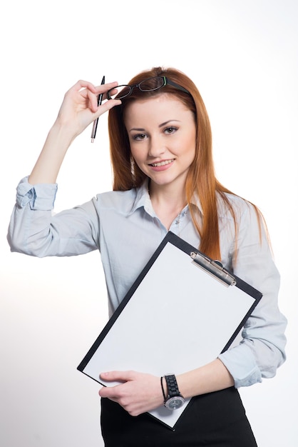 Happy smiling woman in strict clothes and glasses holding a clipboard on grey