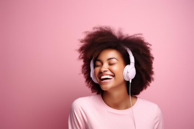 Photo happy smiling woman with afro curly hair and headphones laughing female model listen to music on pink pastel background