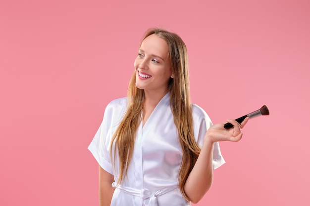 Happy smiling woman with blush and powder brush