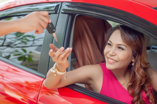 車のキーを持つ幸せな笑顔の女性