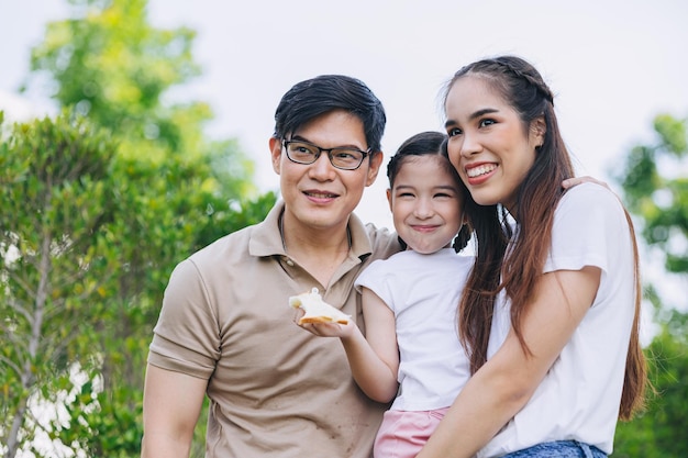happy smiling young asian family happiness with child little girl standing together outdoor green park