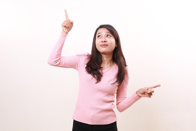 Photo happy smiling young asian girl standing while pointing both sides product advertisement and promotional concept isolated on white background