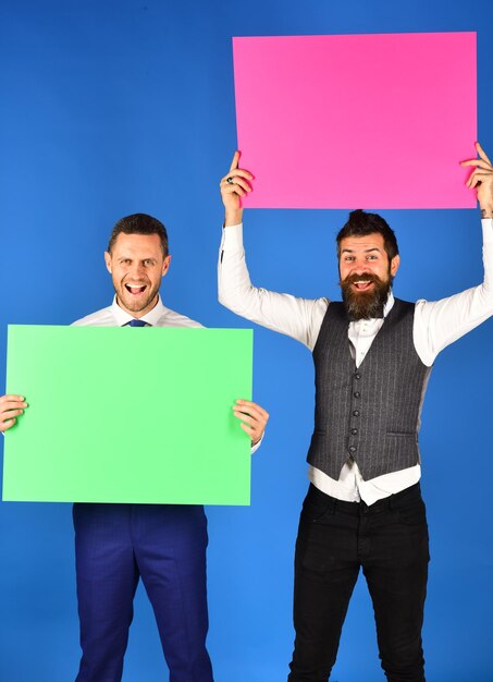 Happy smiling young businessmen showing blank signboards