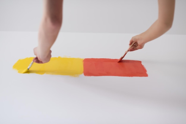 happy smiling young couple painting interior wall of new house