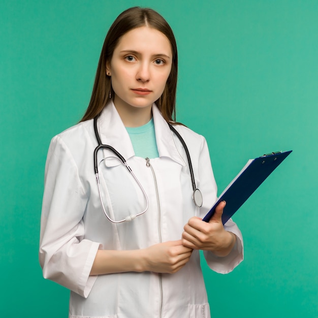 Giovane medico femminile sorridente felice con i appunti