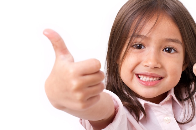 Happy, smiling young little girl giving thumb up gesture, isolated