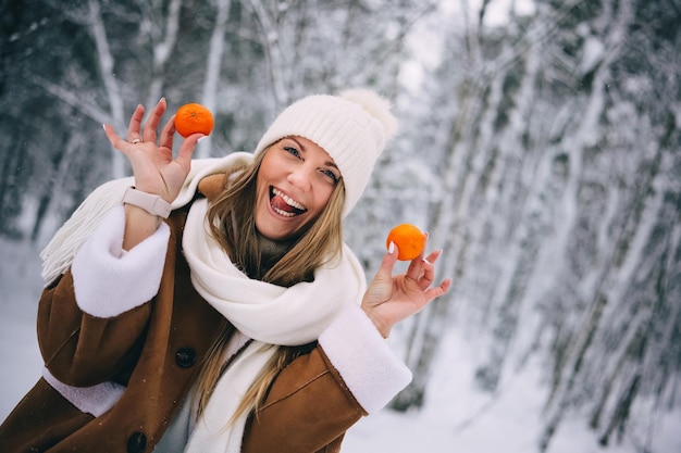 Photo happy smiling young woman holding tangerines in hands