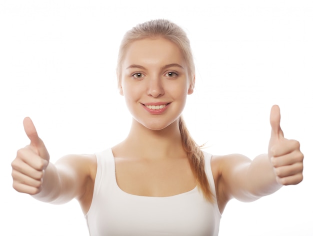 Happy smiling young woman with thumbs up gesture