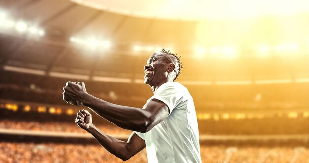 happy soccer player celebrate a victory on a professional football stadium