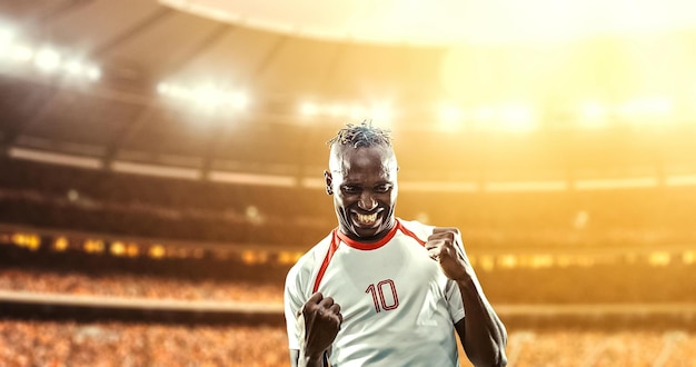 happy soccer player celebrate a victory on a professional football stadium
