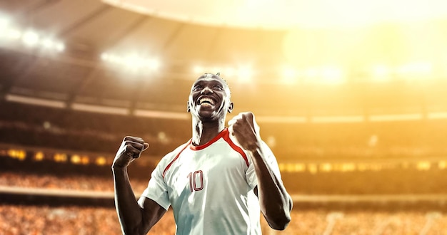happy soccer player celebrate a victory on a professional football stadium