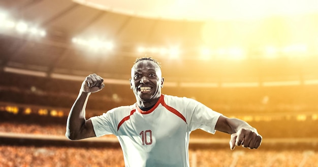 happy soccer player celebrate a victory on a professional football stadium