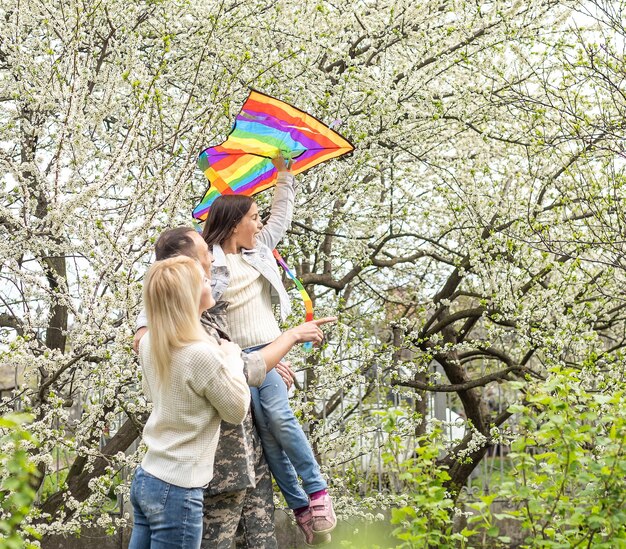 Happy soldier with family in park.