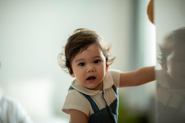 家族の父と母と一緒にサポートすることによって家で遊ぶ幸せな息子の子の赤ちゃん