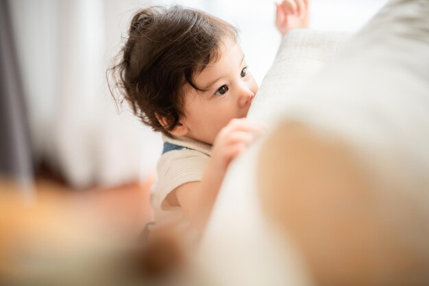 家族の父と母と一緒にサポートすることによって家で遊ぶ幸せな息子の子の赤ちゃん