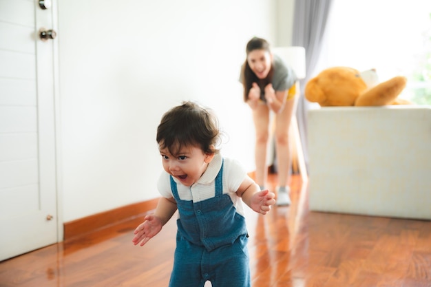 家族の父と母と一緒にサポートすることによって家で遊ぶ幸せな息子の子の赤ちゃん