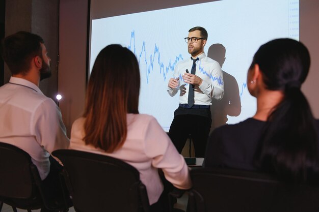 Happy speaker giving presentation in conference hall