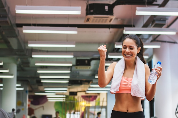 Happy sports woman celebrating her success in gym