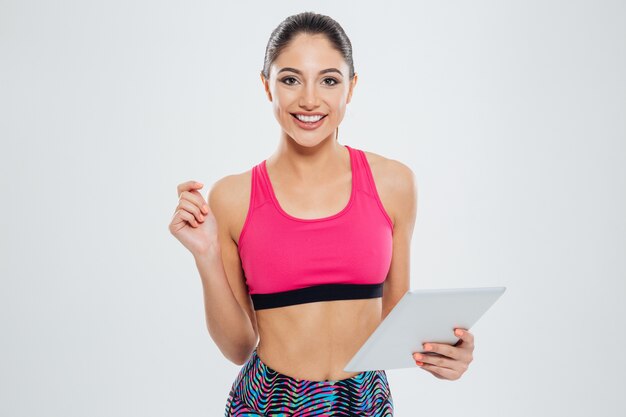 Happy sports woman using tablet computer