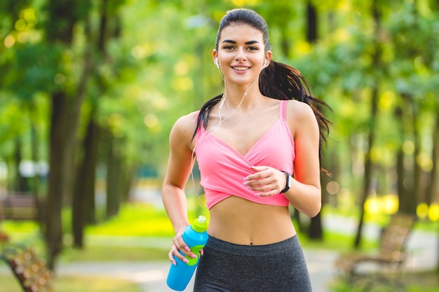 The happy sportswoman running in the park