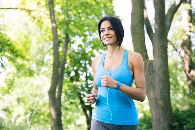 Happy sporty woman running outdoors