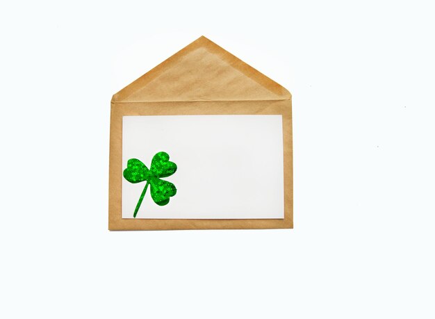 Happy St Patricks Day composition Green shamrock clover leaves on craft envelope Flat lay top view