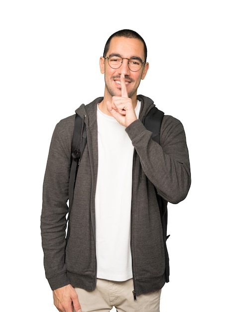 Happy student asking for silence gesturing with his finger