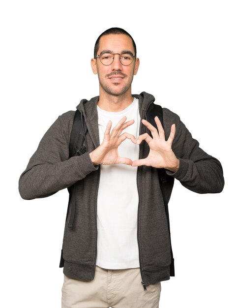 Happy student doing a gesture of love with his hands