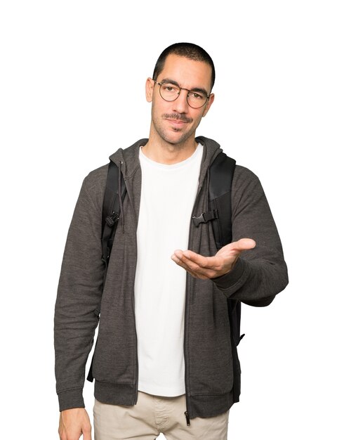 Happy student doing a gesture of welcome with his hand