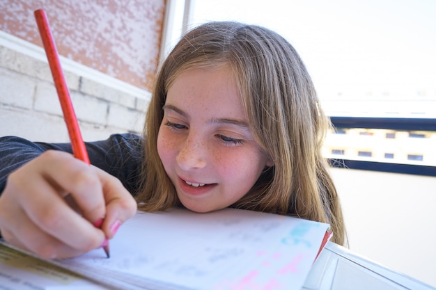 Счастливая девушка студента делая ее домашнюю работу