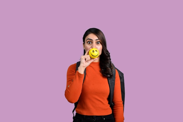 Happy student girl holding ball indian pakistani model