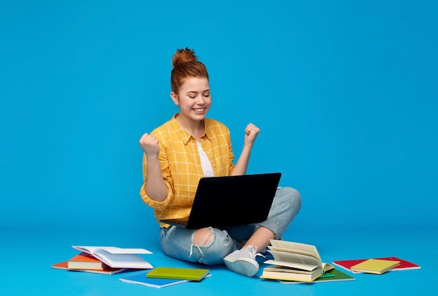 happy student girl with laptop celebrating success