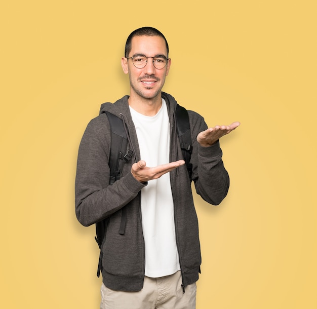 Happy student holding something with his hand