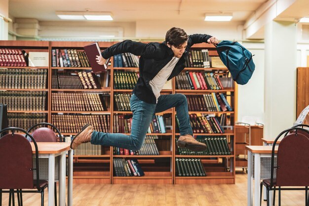 本とバックパックでジャンプする幸せな学生b