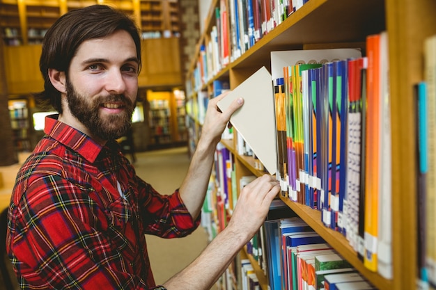 Happy student picking book in library