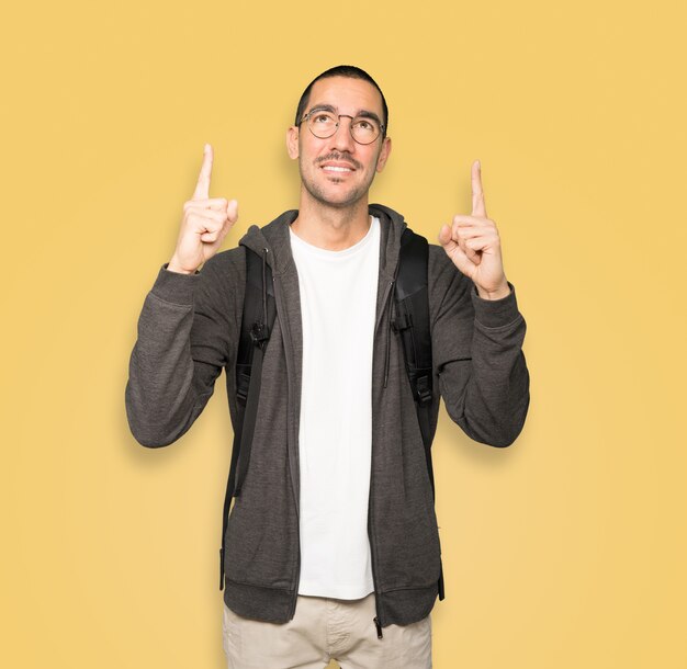 Happy student pointing up with his finger