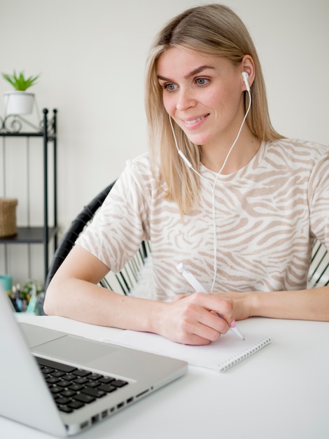 Photo happy student wearing headphones and writes