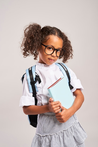 Happy student with backpack holding a book