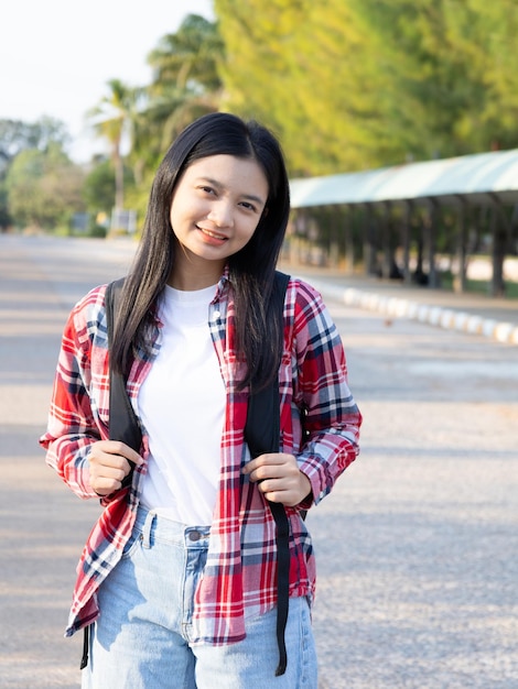 バックパックを持って学校へ歩く幸せな学生の少女は