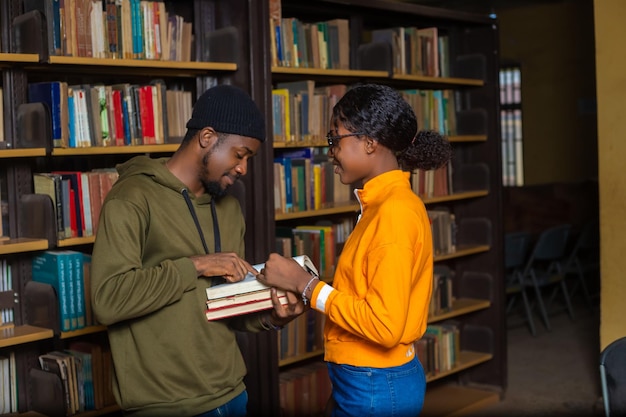 Happy students couple in school studying for exams together