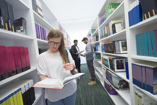 Photo happy students group in school library selecting books to read and walking