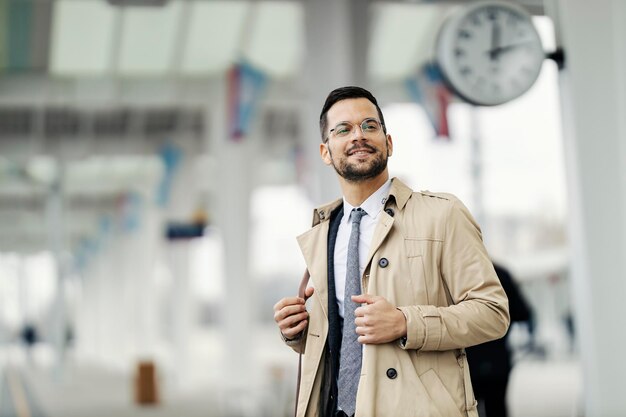 A happy stylish businessman at train stating rushing on work