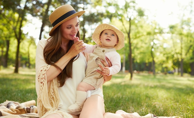 Happy stylish and loving family. mother playing with her baby outdoor. lovely baby smiles and enjoys. Mother's day concept.