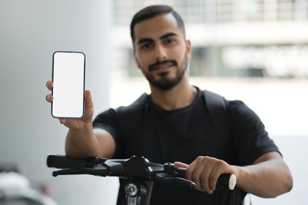 Happy successful businessman looking at camera and showing smartphone