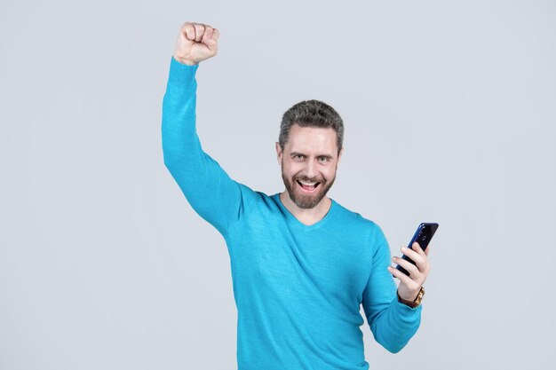 Happy successful man with beard with smartphone success