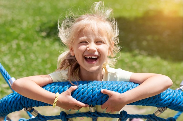 ハッピー サマー ホリデー面白い子供スイング自然の背景に楽しんで笑顔の子供の肖像画